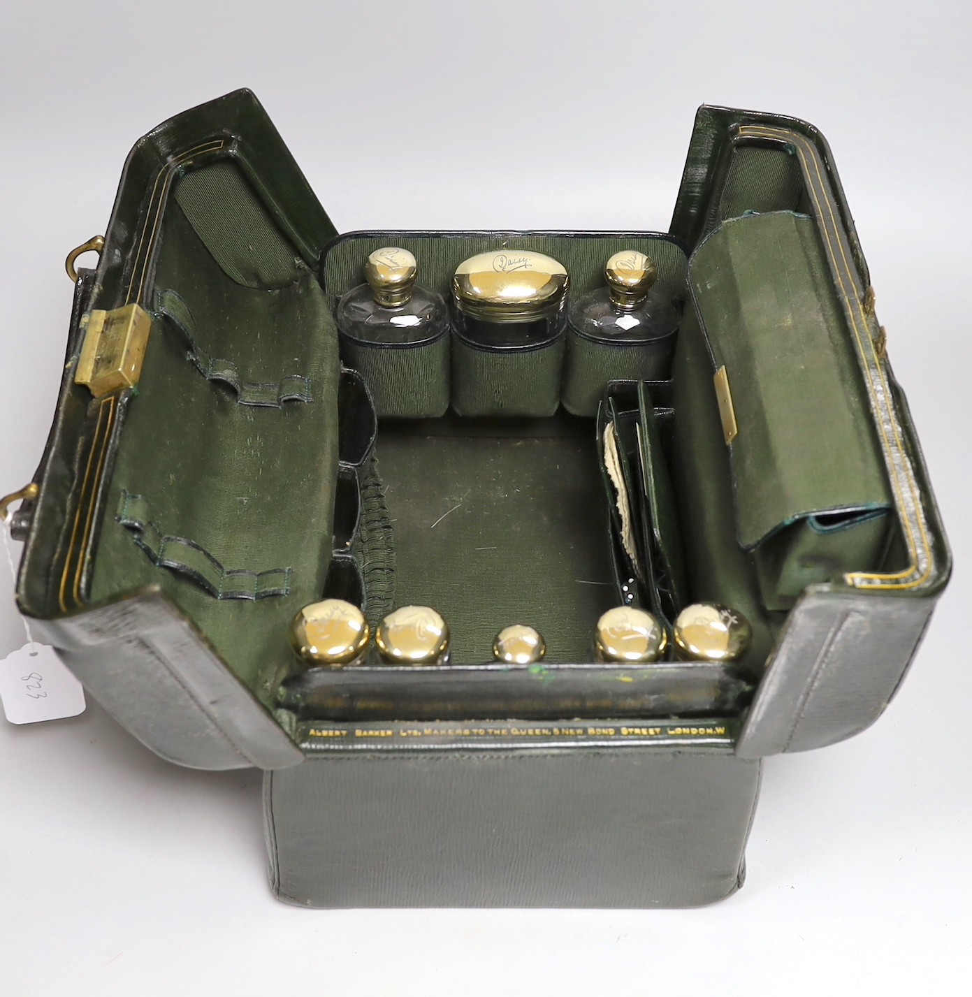 A late Victorian leather Gladstone toilet case, containing eight silver gilt mounted glass toilet jars, all engraved 'Daisy', two makers, London, 1894 & 1898, bag length 33cm.